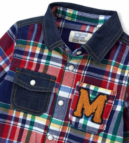 Καρό πουκάμισο φανέλας με μακριά μανίκια και ένθετα από τζιν. Μπροστινό άνοιγμα με κουμπιά-σούστες, τσέπες απλικέ, τύπωμα στο πίσω μέρος του ώμου και κεντημένη ετικέτα στο πλάι.