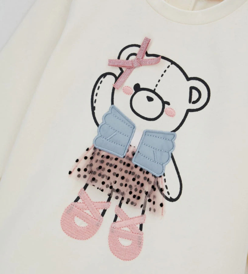 Μπλούζα από ελαστικό βαμβάκι με στρογγυλή λαιμόκοψη και μακριά μανίκια. Διακοσμημένη με τύπωμα, κέντημα και απλικέ στο μπροστινό μέρος, για χαριτωμένη και κομψή εμφάνιση. Για τα μεγέθη έως 2–3 ετών διαθέτει πρακτικό άνοιγμα με κουμπιά για εύκολο ντύσιμο. Ιδανική για καθημερινές κοριτσίστικες εμφανίσεις με στυλ.