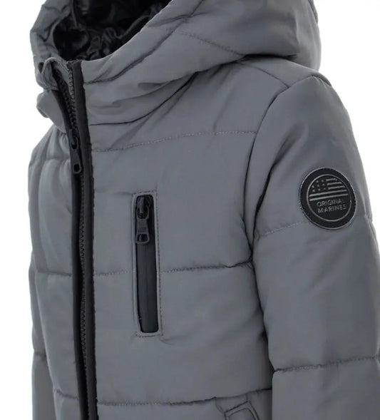 Παιδικό μπουφάν από ανακλαστικό καπιτονέ νάιλον με επένδυση και εσωτερικό σε αντίθεση χρώματος. Διαθέτει άνοιγμα με φερμουάρ, πρακτικές τσέπες, ελαστικό τελείωμα στη βάση και ριμπ μανσέτες για απόλυτη προστασία από το κρύο. Ιδανικό για καθημερινές εμφανίσεις με στυλ και ασφάλεια.