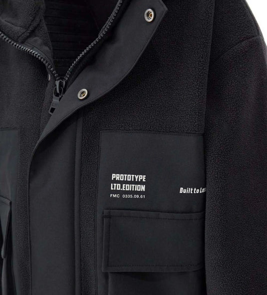 Ζεστό και μοντέρνο παιδικό μπουφάν από fleece με νάιλον λεπτομέρειες. Διαθέτει κουκούλα, άνοιγμα με φερμουάρ και κουμπιά-σούστες, τυπωμένες τσέπες και ελαστικές μανσέτες για άνετη εφαρμογή. Ιδανικό για casual χειμερινές εμφανίσεις με στυλ και πρακτικότητα.