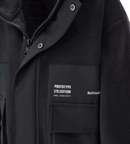 Ζεστό και μοντέρνο παιδικό μπουφάν από fleece με νάιλον λεπτομέρειες. Διαθέτει κουκούλα, άνοιγμα με φερμουάρ και κουμπιά-σούστες, τυπωμένες τσέπες και ελαστικές μανσέτες για άνετη εφαρμογή. Ιδανικό για casual χειμερινές εμφανίσεις με στυλ και πρακτικότητα.