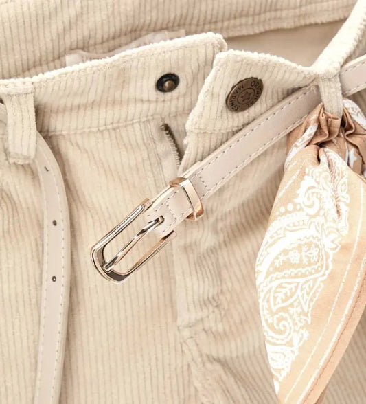 Παντελόνι καμπάνα από βελούδινο κοτλέ ύφασμα με ρυθμιζόμενη μέση, μπροστινό κλείσιμο με κουμπί, τσέπες μπροστά και πίσω και αποσπώμενη ζώνη με φουλάρι για μια μοντέρνα και ευέλικτη πινελιά.