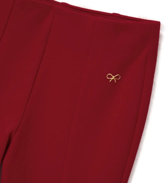 Παντελόνι σε ελαστικό πλεκτό ύφασμα Milano με ψηλή μέση, πιέτες και σκίσιμο στο τελείωμα. Διακοσμημένο με μεταλλική εκτύπωση στο μπροστινό μέρος, ιδανικό για κάθε περίσταση.