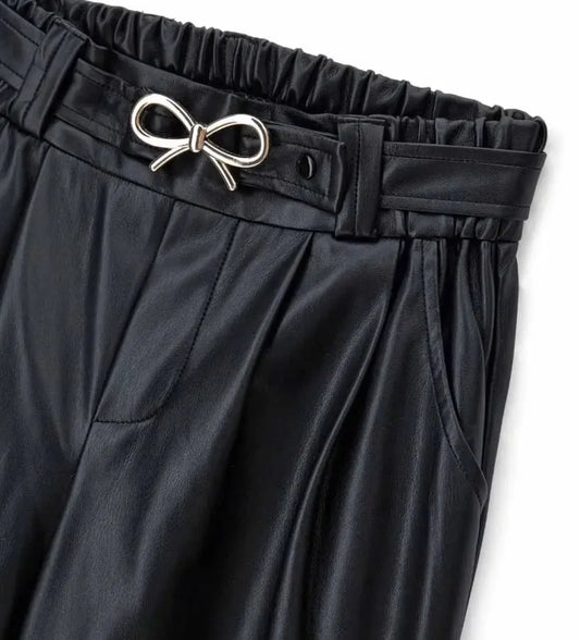 Παντελόνι από οικοδερμάτινη ύλη με ελαστική μέση και μπροστινές τσέπες. Φαρδιά γραμμή στα πόδια και αφαιρούμενη ζώνη με μεταλλική αγκράφα για ένα μοντέρνο, τολμηρό και σούπερ στιλάτο look.