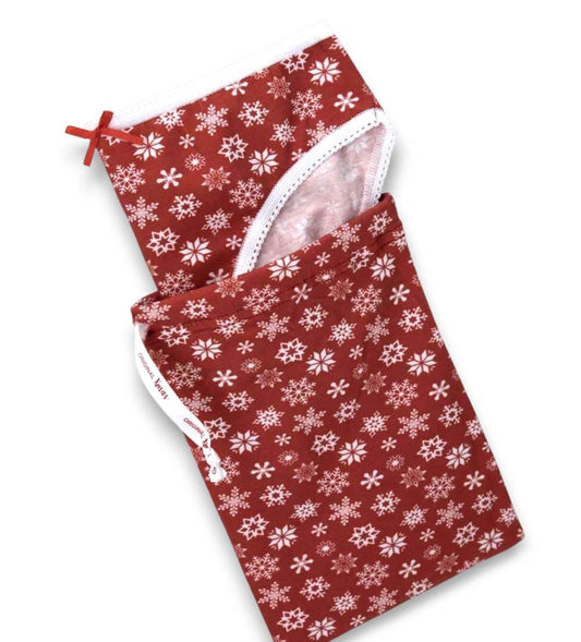 Βαμβακερό σλιπ με ελαστική μέση και χριστουγεννιάτικο σχέδιο allover. Με ελαστικό και διακοσμητικό τελείωμα, εμπλουτισμένο με μικρό σατέν φιόγκο στο μπροστινό μέρος για μια απαλή και κομψή πινελιά.