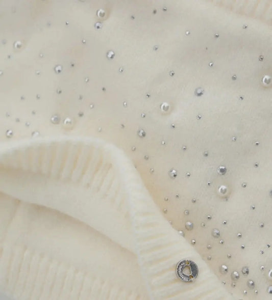 Πλεκτός λαιμός με διακοσμητικά στρας, τρουκς και πέρλες. Ένα ζεστό και εκλεπτυσμένο αξεσουάρ, ιδανικό για να χαρίσει κομψότητα και λάμψη στις χειμερινές εμφανίσεις.