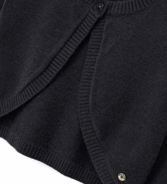 Πλεκτό μπολερό από μείγμα μαλλιού με στρογγυλή λαιμόκοψη, άνοιγμα με κουμπί και ριμπ τελειώματα σε λαιμό και μανσέτες. Ένα κομψό και εκλεπτυσμένο ρούχο, διακοσμημένο με μεταλλικό μενταγιόν.