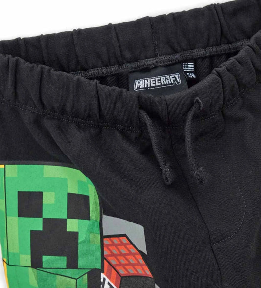 Παιδικό παντελόνι φόρμας Minecraft από βαμβάκι, με ελαστική μέση και ρυθμιζόμενο κορδόνι για τέλεια εφαρμογή. Διαθέτει πλαϊνά τυπώματα και λάστιχο στα τελειώματα για άνεση και πρακτικότητα. Ιδανικό για καθημερινές εμφανίσεις με μοντέρνο, gamer στυλ.