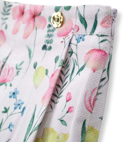 Λεπτομέρεια από τα διακοσμητικά κουμπιά και τις πιέτες στη φλοράλ κοριτσίστικη βερμούδα.