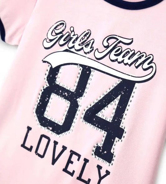 Λεπτομέρεια από τα στρασάκια και τα contrast τελειώματα της παιδικής μπλούζας.