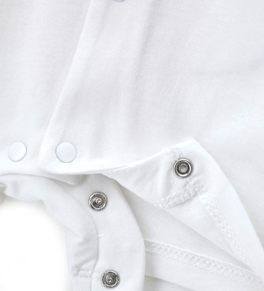 Κοντινό πλάνο στα κουμπιά-σούστες ανάμεσα στα πόδια και την υφασμάτινη ετικέτα στον ώμο.