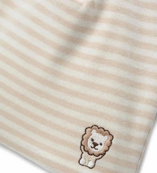 Κοντινό πλάνο στη βαμβακερή ριγέ ύφανση και το λεπτομερές κέντημα του λιονταριού.