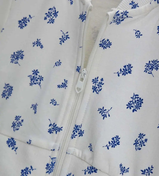 Λεπτομέρεια από το ribbed τελείωμα και το φλοράλ τύπωμα στο βρεφικό fleece τζάκετ.