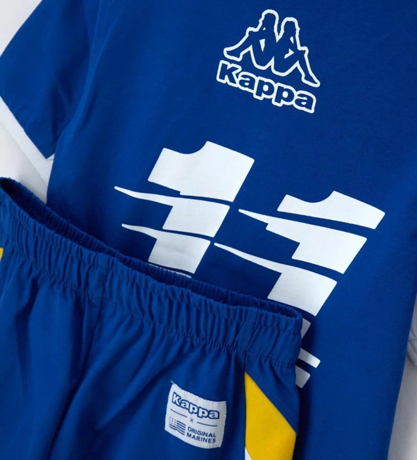 Παιδικό σετ Kappa για αγόρι με μπλε T-shirt και βερμούδα με λογότυπο και λευκές λεπτομέρειες.