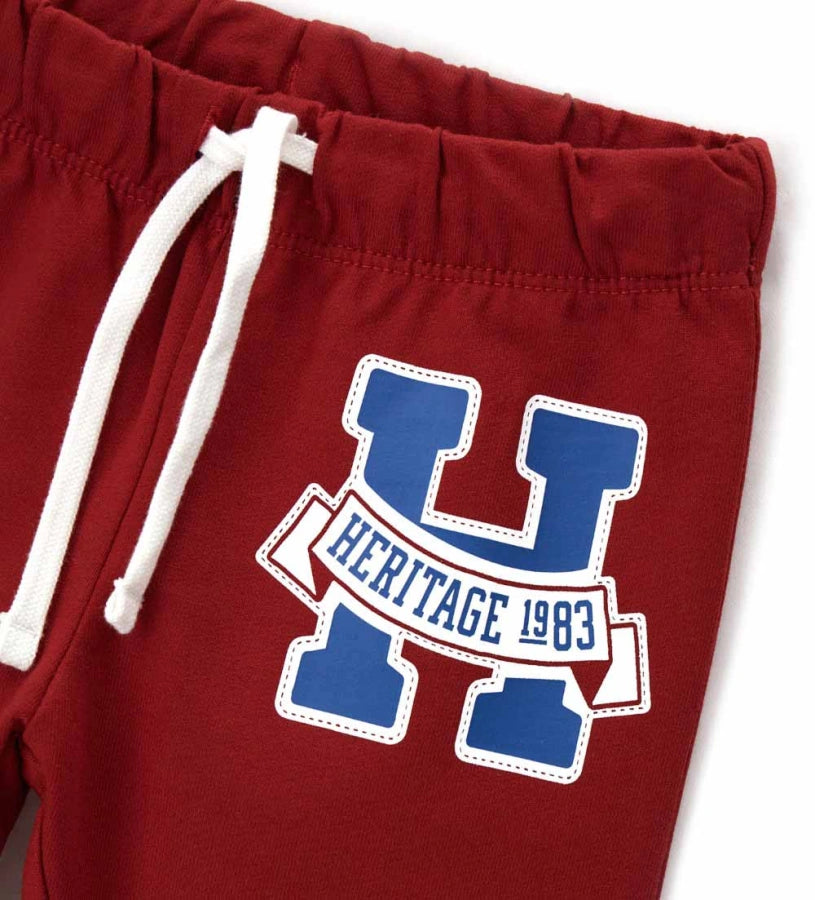 Παιδικό παντελόνι σε κόκκινο χρώμα από ελαστικό βαμβακερό fleece, ιδανικό για καθημερινή άνεση. Διαθέτει ρυθμιζόμενη μέση με κορδόνι και διακριτικό τύπωμα στο μπροστινό μέρος. Ένα πρακτικό και μοντέρνο κομμάτι, ιδανικό για casual παιδικές εμφανίσεις.