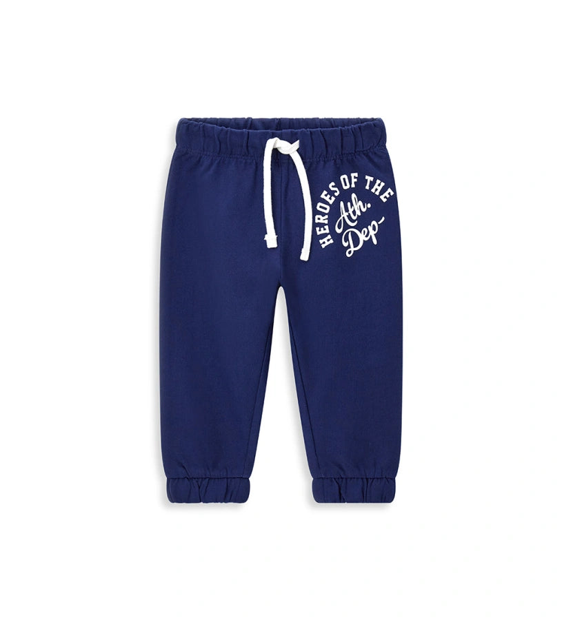 Παιδικό παντελόνι σε μπλε χρώμα από ελαστικό βαμβακερό fleece, ιδανικό για καθημερινή άνεση. Διαθέτει ρυθμιζόμενη μέση με κορδόνι και διακριτικό τύπωμα στο μπροστινό μέρος. Ένα πρακτικό και μοντέρνο κομμάτι για κάθε παιδική εμφάνιση.