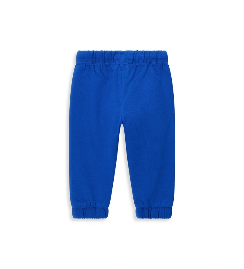Παιδικό παντελόνι σε μπλε ανοιχτό χρώμα από ελαστικό βαμβακερό fleece, ιδανικό για καθημερινή άνεση. Διαθέτει ρυθμιζόμενη μέση με κορδόνι και διακριτικό τύπωμα στο μπροστινό μέρος. Άνετο, πρακτικό και μοντέρνο, ιδανικό για κάθε περίσταση.