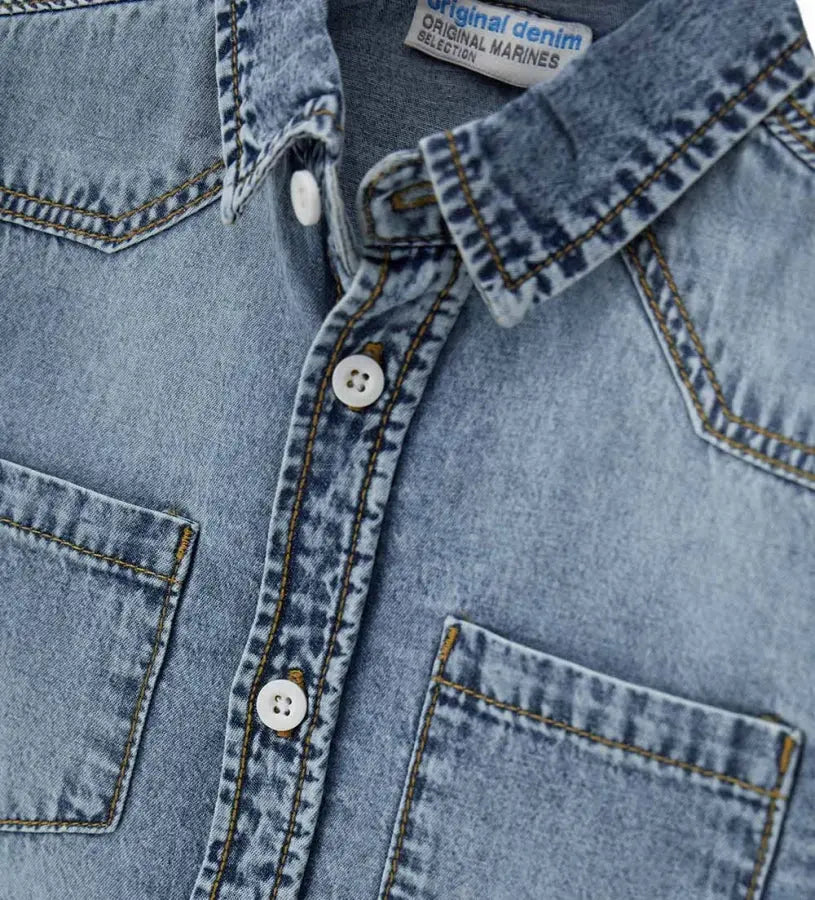 Λεπτομέρεια από την τσέπη και τα κουμπιά στο παιδικό τζιν πουκάμισο.