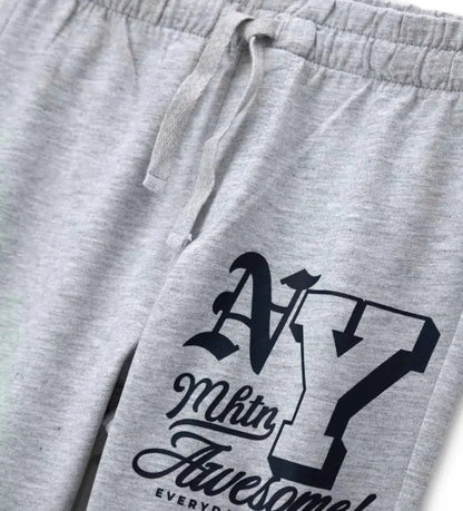 Λεπτομέρεια από το λάστιχο στους αστραγάλους και το τύπωμα στο γκρι παιδικό παντελόνι.