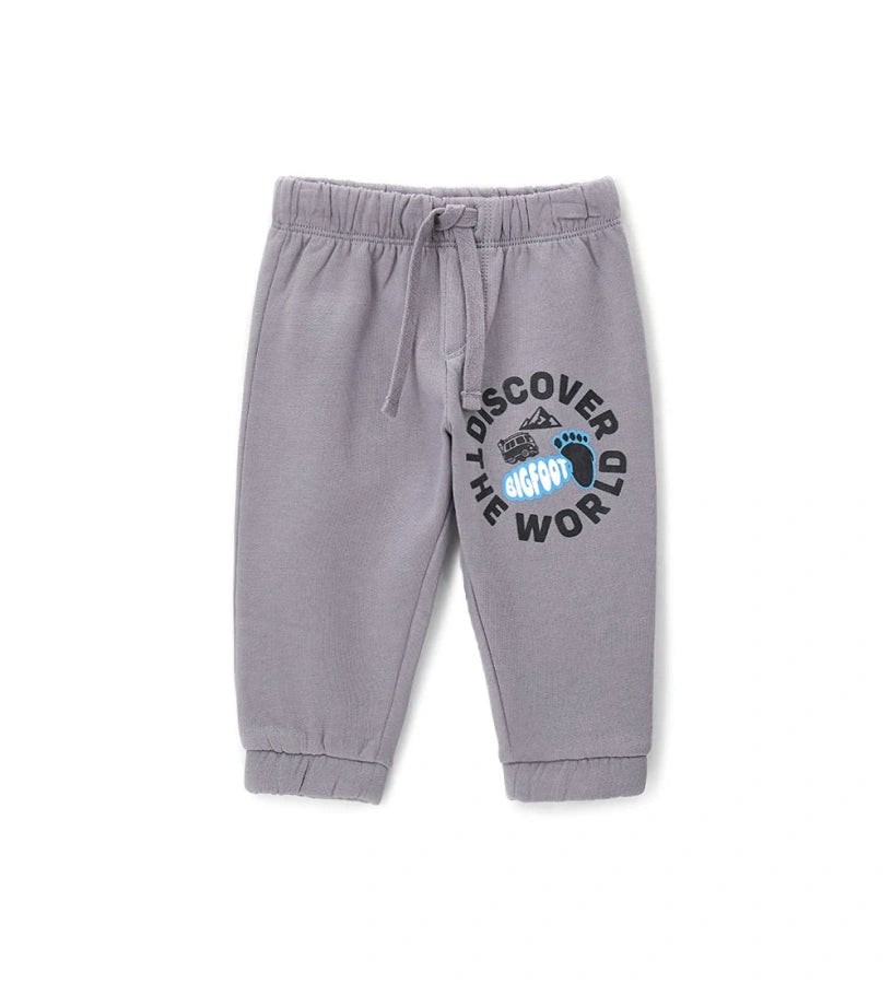 Γκρι παιδικό παντελόνι από ζεστό βαμβακερό fleece, ιδανικό για τις κρύες μέρες του χειμώνα. Διαθέτει ελαστική μέση με ρυθμιζόμενο κορδόνι, λάστιχο στο τελείωμα και πλαϊνό τύπωμα. Άνετο και πρακτικό, συνδυάζει στυλ και λειτουργικότητα για κάθε καθημερινή εμφάνιση.