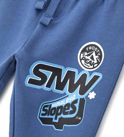 Μπλε παιδικό παντελόνι από ζεστό βαμβακερό fleece, ιδανικό για τον χειμώνα. Διαθέτει ελαστική μέση με ρυθμιζόμενο κορδόνι, λάστιχο στο τελείωμα και πλαϊνό τύπωμα. Άνετο και μοντέρνο, προσφέρει πρακτικότητα και στυλ στις καθημερινές εμφανίσεις των παιδιών.