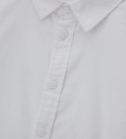 Λεπτομέρεια από την ύφανση Oxford και τα κουμπιά στο αγορίστικο πουκάμισο.