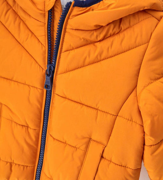 Παιδικό καπιτονέ μπουφάν από ανθεκτικό ripstop νάιλον με κουκούλα και εσωτερικό σε αντίθεση χρώμα. Διαθέτει άνοιγμα με φερμουάρ, τσέπες με κουμπιά-σούστες και ελαστικά τελειώματα για καλύτερη εφαρμογή. Ζεστό, πρακτικό και μοντέρνο, ιδανικό για τις χειμερινές περιπέτειες των παιδιών.