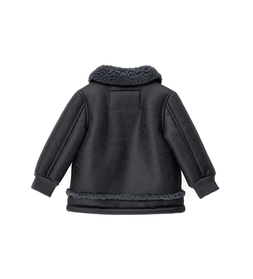 Παιδικό μπουφάν από ψεύτικο δέρμα προβάτου με φινιρίσματα σε ακατέργαστο στυλ, κομψό και ζεστό. Διαθέτει άνοιγμα με φερμουάρ, μπροστινές τσέπες με κουμπιά-σούστες και ριμπ μανσέτες. Ιδανικό για στιλάτες χειμερινές εμφανίσεις με άνεση και χαρακτήρα.