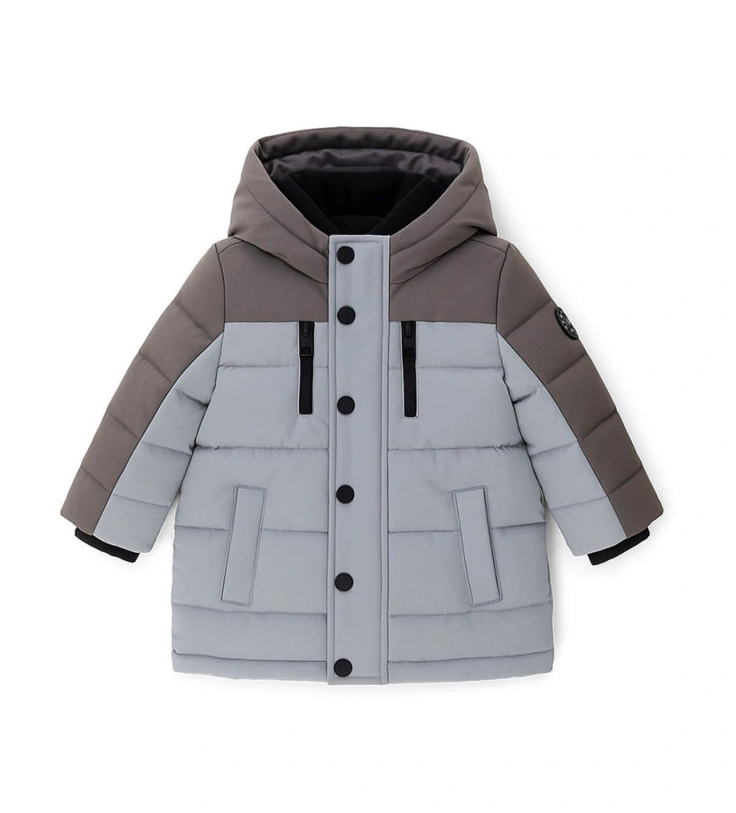 Παιδικό παρκά με κουκούλα από καπιτονέ και επενδυμένο νάιλον, με εσωτερικές λεπτομέρειες από ζεστή οικολογική γούνα για περισσότερη άνεση. Διαθέτει άνοιγμα με φερμουάρ και κουμπιά-σούστες, διακοσμητικές τσέπες με φερμουάρ και ριμπ μανσέτες. Ένα κομψό και πρακτικό μπουφάν, ιδανικό για τις κρύες χειμερινές μέρες.