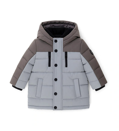 Παιδικό παρκά με κουκούλα από καπιτονέ και επενδυμένο νάιλον, με εσωτερικές λεπτομέρειες από ζεστή οικολογική γούνα για περισσότερη άνεση. Διαθέτει άνοιγμα με φερμουάρ και κουμπιά-σούστες, διακοσμητικές τσέπες με φερμουάρ και ριμπ μανσέτες. Ένα κομψό και πρακτικό μπουφάν, ιδανικό για τις κρύες χειμερινές μέρες.
