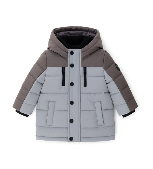 Παιδικό παρκά με κουκούλα από καπιτονέ και επενδυμένο νάιλον, με εσωτερικές λεπτομέρειες από ζεστή οικολογική γούνα για περισσότερη άνεση. Διαθέτει άνοιγμα με φερμουάρ και κουμπιά-σούστες, διακοσμητικές τσέπες με φερμουάρ και ριμπ μανσέτες. Ένα κομψό και πρακτικό μπουφάν, ιδανικό για τις κρύες χειμερινές μέρες.