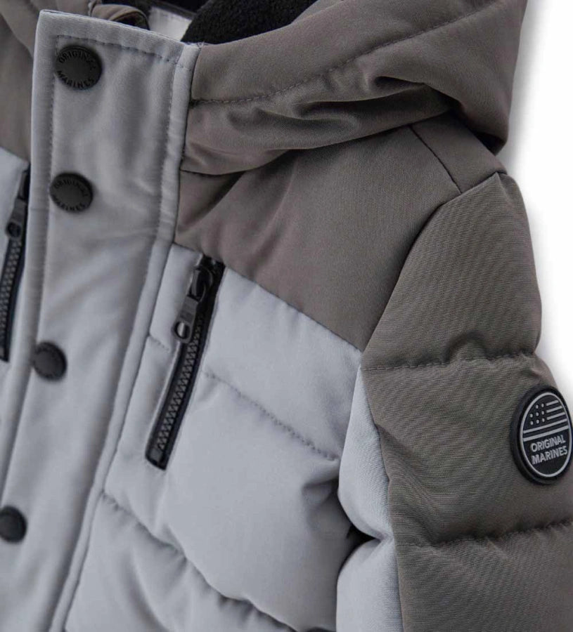 Παιδικό παρκά με κουκούλα από καπιτονέ και επενδυμένο νάιλον, με εσωτερικές λεπτομέρειες από ζεστή οικολογική γούνα για περισσότερη άνεση. Διαθέτει άνοιγμα με φερμουάρ και κουμπιά-σούστες, διακοσμητικές τσέπες με φερμουάρ και ριμπ μανσέτες. Ένα κομψό και πρακτικό μπουφάν, ιδανικό για τις κρύες χειμερινές μέρες.