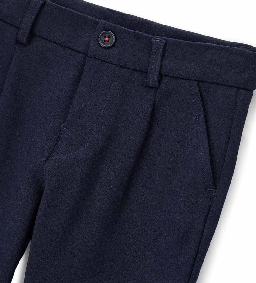 Παντελόνι chinos από ύφασμα Milano. Διαθέτει ρυθμιζόμενη μέση, πρακτικές τσέπες και κομψή κεντημένη ετικέτα στο πίσω μέρος. Για τα μεγέθη έως 2–3 ετών το άνοιγμα είναι με κουμπί, ενώ από το μέγεθος 3–4 ετών και πάνω διαθέτει φερμουάρ.