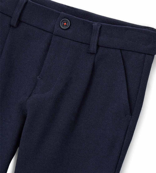 Παντελόνι chinos από ύφασμα Milano. Διαθέτει ρυθμιζόμενη μέση, πρακτικές τσέπες και κομψή κεντημένη ετικέτα στο πίσω μέρος. Για τα μεγέθη έως 2–3 ετών το άνοιγμα είναι με κουμπί, ενώ από το μέγεθος 3–4 ετών και πάνω διαθέτει φερμουάρ.