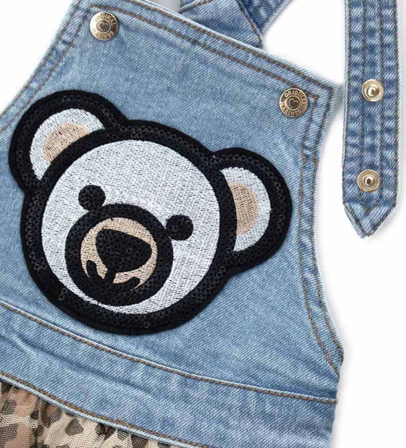 Ένα μοντέρνο και ξεχωριστό κομμάτι που συνδυάζει το casual denim με την αέρινη κομψότητα του τούλι. Οι τιράντες με κουμπιά-σούστα προσφέρουν άνεση και ευκολία στο ντύσιμο, ενώ η επένδυση από βαμβακερή ποπλίνα εξασφαλίζει απαλότητα στο δέρμα. Το κεντημένο patch με παγιέτες στο μπροστινό μέρος δίνει μια λαμπερή πινελιά που ξεχωρίζει.