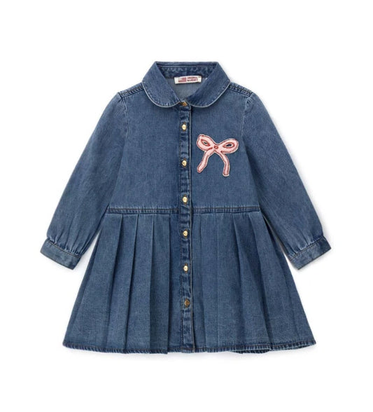 Τζιν φόρεμα με μακριά μανίκια και στρογγυλή λαιμόκοψη. Πρακτικό κουμπί τύπου press στο μπροστινό μέρος και λεπτή διακοσμητική κεντητική για ένα look κατάλληλο για κάθε περίσταση.