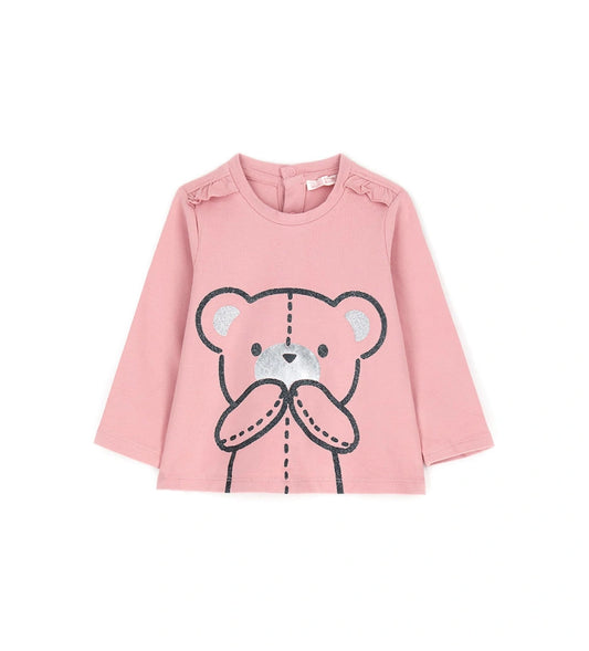 Μπλούζα από ελαστικό βαμβάκι με στρογγυλή λαιμόκοψη, μακριά μανίκια, βολάν στους ώμους και τύπωμα με γκλίτερ και μεταλλικές λεπτομέρειες στο μπροστινό μέρος. Για τα μεγέθη έως 2–3 ετών διαθέτει πρακτικό άνοιγμα με κουμπιά.