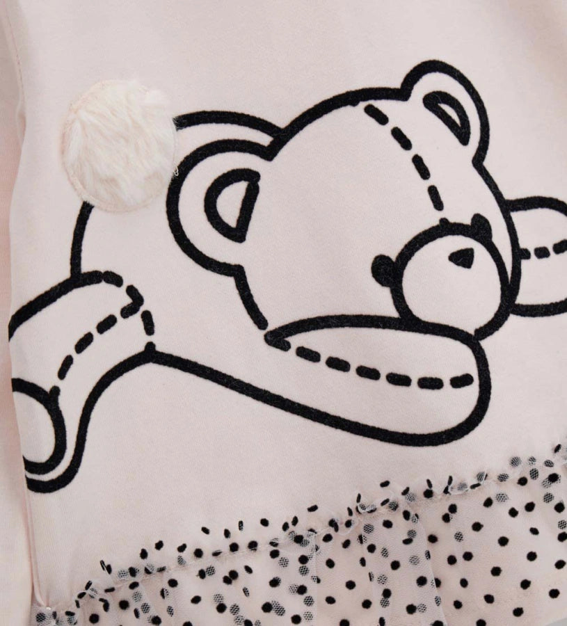 Μπλούζα από ελαστικό βαμβάκι με στρογγυλή λαιμόκοψη και μακριά μανίκια. Διαθέτει διακοσμητικά βολάν από τούλι στο τελείωμα και τύπωμα με flock υφή και απλικέ από ψεύτικη γούνα στο μπροστινό μέρος. Για τα μεγέθη έως 2–3 ετών περιλαμβάνει πρακτικό άνοιγμα με κουμπιά για μεγαλύτερη ευκολία. Ιδανική για γλυκές και κομψές κοριτσίστικες εμφανίσεις.