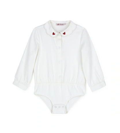 Παιδικό κορμάκι-πουκάμισο από βαμβακερό ποπλίνα με κόψιμο στη μέση και κάτω μέρος από βαμβακερό jersey για άνετη εφαρμογή. Διαθέτει γιακά με κέντημα καρδιάς, μπροστινό άνοιγμα με κουμπιά και κουμπιά στο εσωτερικό του καβάλου και στις μανσέτες. Ένα κομψό και πρακτικό κομμάτι, ιδανικό για ιδιαίτερες εμφανίσεις με στυλ.