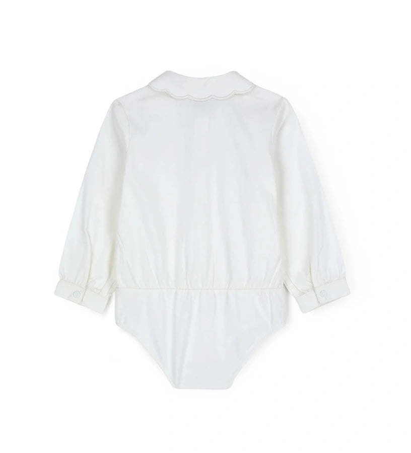 Παιδικό κορμάκι-πουκάμισο από βαμβακερό ποπλίνα με κόψιμο στη μέση και κάτω μέρος από βαμβακερό jersey για άνετη εφαρμογή. Διαθέτει γιακά με κέντημα καρδιάς, μπροστινό άνοιγμα με κουμπιά και κουμπιά στο εσωτερικό του καβάλου και στις μανσέτες. Ένα κομψό και πρακτικό κομμάτι, ιδανικό για ιδιαίτερες εμφανίσεις με στυλ.