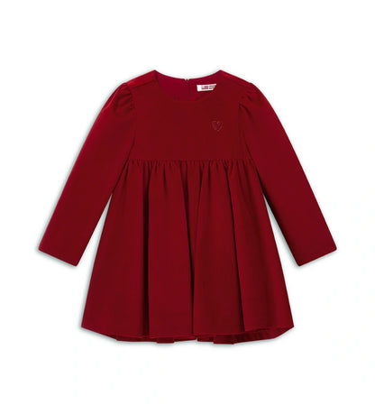 Βελούδινο φόρεμα με μακριά μανίκια και στρογγυλή λαιμόκοψη, με επένδυση από απαλό βαμβάκι. Διαθέτει άνοιγμα στο πίσω μέρος με κρυφό φερμουάρ και κέντημα στην πλευρά της καρδιάς.