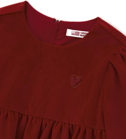 Βελούδινο φόρεμα με μακριά μανίκια και στρογγυλή λαιμόκοψη, με επένδυση από απαλό βαμβάκι. Διαθέτει άνοιγμα στο πίσω μέρος με κρυφό φερμουάρ και κέντημα στην πλευρά της καρδιάς.