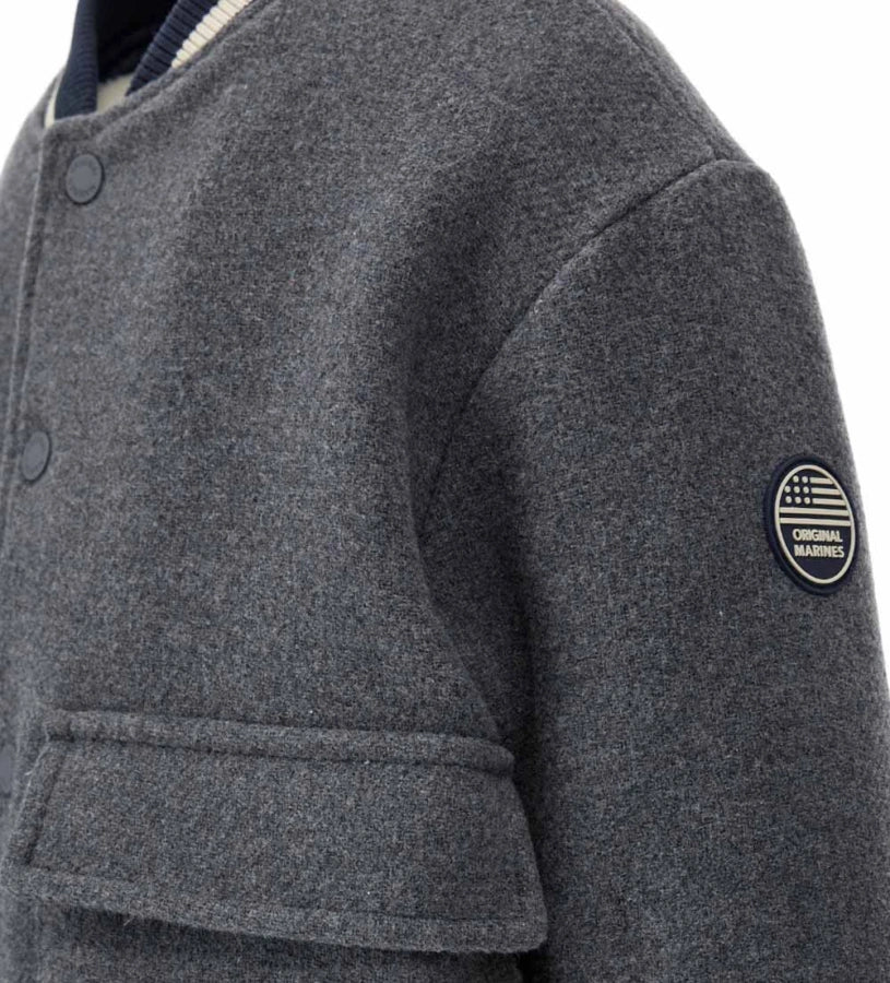 Παιδικό μπουφάν bomber από ύφασμα τύπου μάλλινο με μπροστινές τσέπες και καπιτονέ, επενδυμένη εσωτερική φόδρα για επιπλέον άνεση. Διαθέτει άνοιγμα με κουμπιά-σούστες και ριμπ τελειώματα σε χρώμα βαφής. Ένα ζεστό και μοντέρνο κομμάτι, ιδανικό για στιλάτες χειμερινές εμφανίσεις.