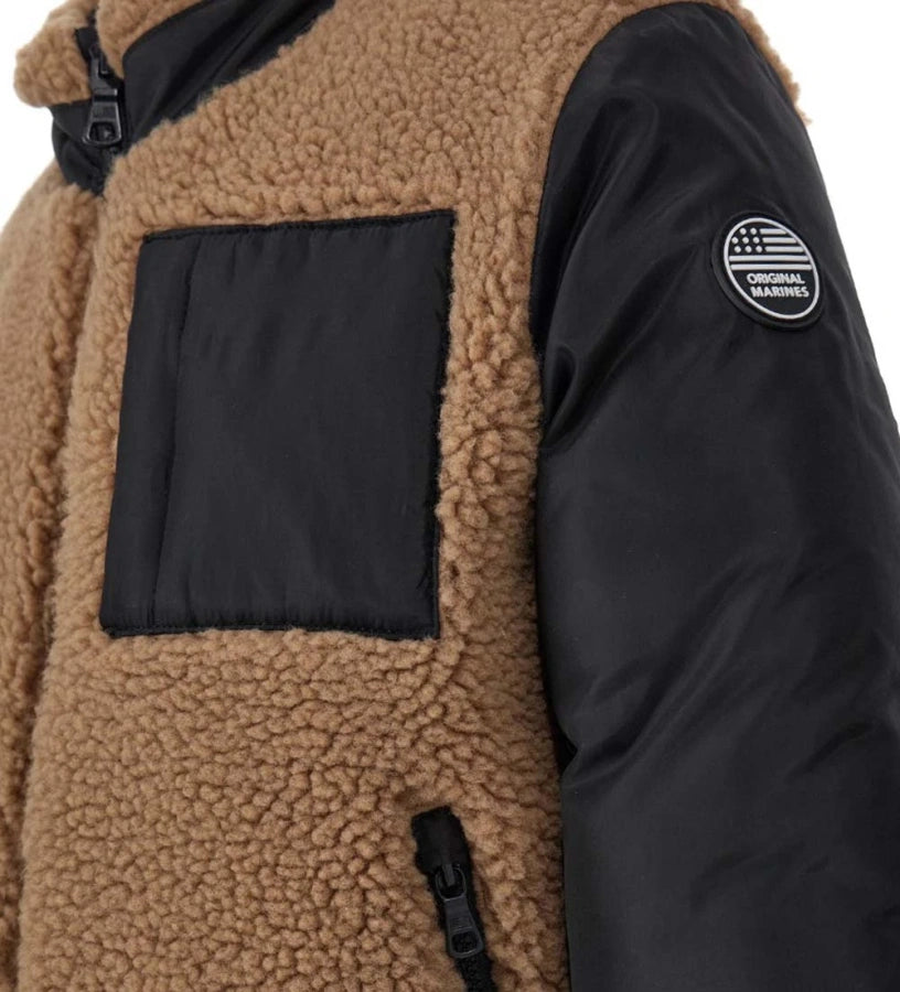 Αναστρέψιμο μπουφάν με επένδυση. Η μία πλευρά από ζεστό οικολογικό ύφασμα τύπου teddy με τσέπη σε αντίθεση και η άλλη από καπιτονέ νάιλον. Διαθέτει άνοιγμα με φερμουάρ και ελαστικές μανσέτες για μεγαλύτερη άνεση.