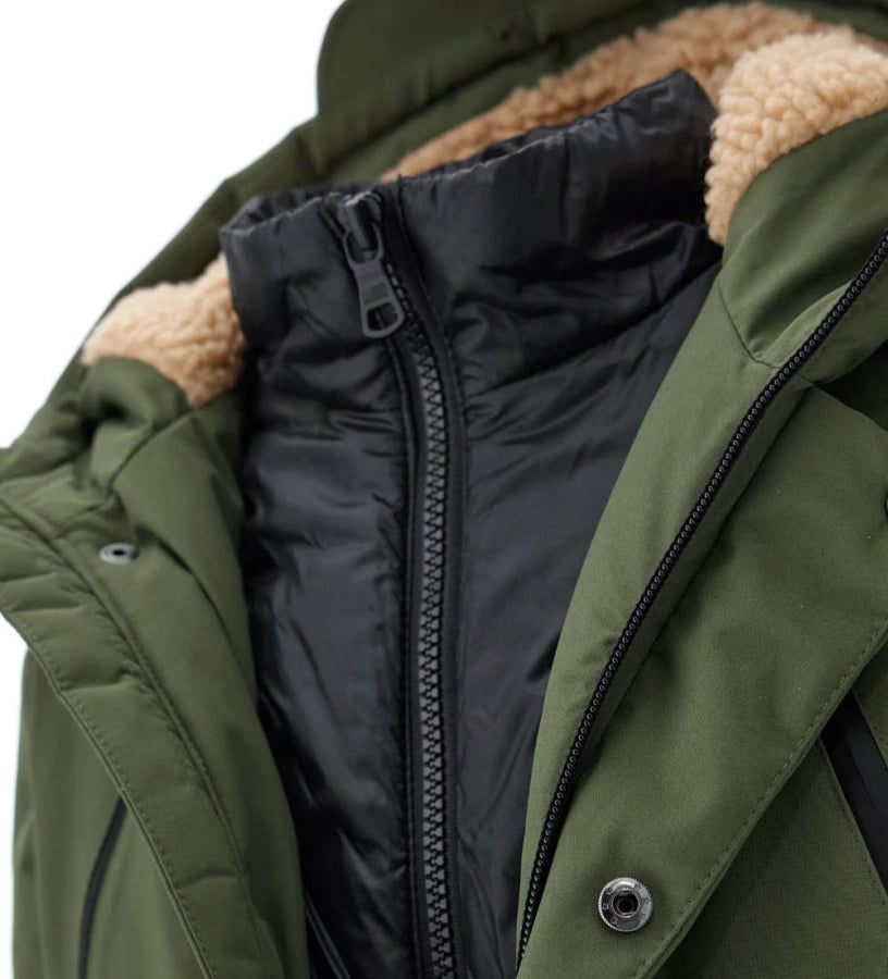 Καπιτονέ μπουφάν τύπου parka από νάιλον με κουκούλα από οικολογική γούνα και αντίθετη εσωτερική φόδρα. Κλείσιμο με φερμουάρ και κουμπιά-σούστες, ριμπ μανίκια για μέγιστη άνεση.