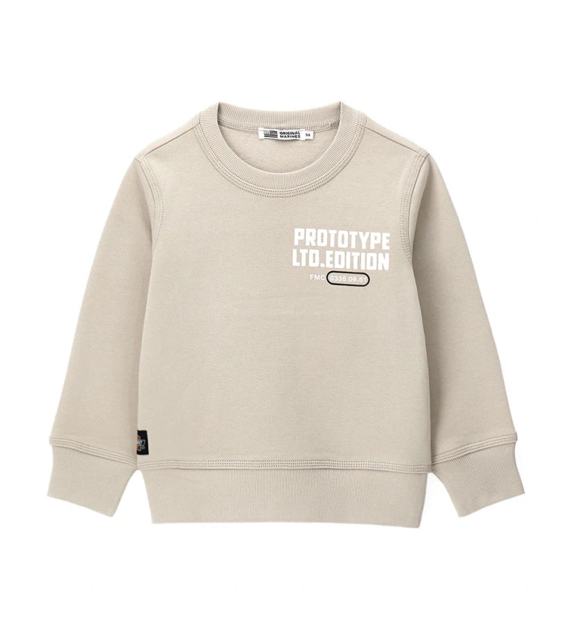 Μπεζ παιδικό φούτερ από βαμβάκι με στρογγυλή λαιμόκοψη και ριμπ τελειώματα. Διακοσμημένο με γραφικό τύπωμα στο μπροστινό και πίσω μέρος, διακοσμητική τομή στην πλάτη και πλαϊνή ετικέτα. Ένα μοντέρνο και άνετο κομμάτι, ιδανικό για casual εμφανίσεις με στυλ.