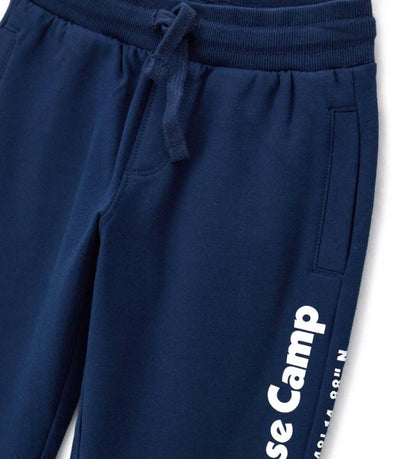 Παντελόνι από ζεστό βαμβακερό fleece, άνετο και μοντέρνο. Διαθέτει ρυθμιζόμενη μέση με κορδόνι, πλαϊνές τσέπες, διακοσμητικό τύπωμα και ριμπ τελειώματα για μια προσεγμένη εμφάνιση.