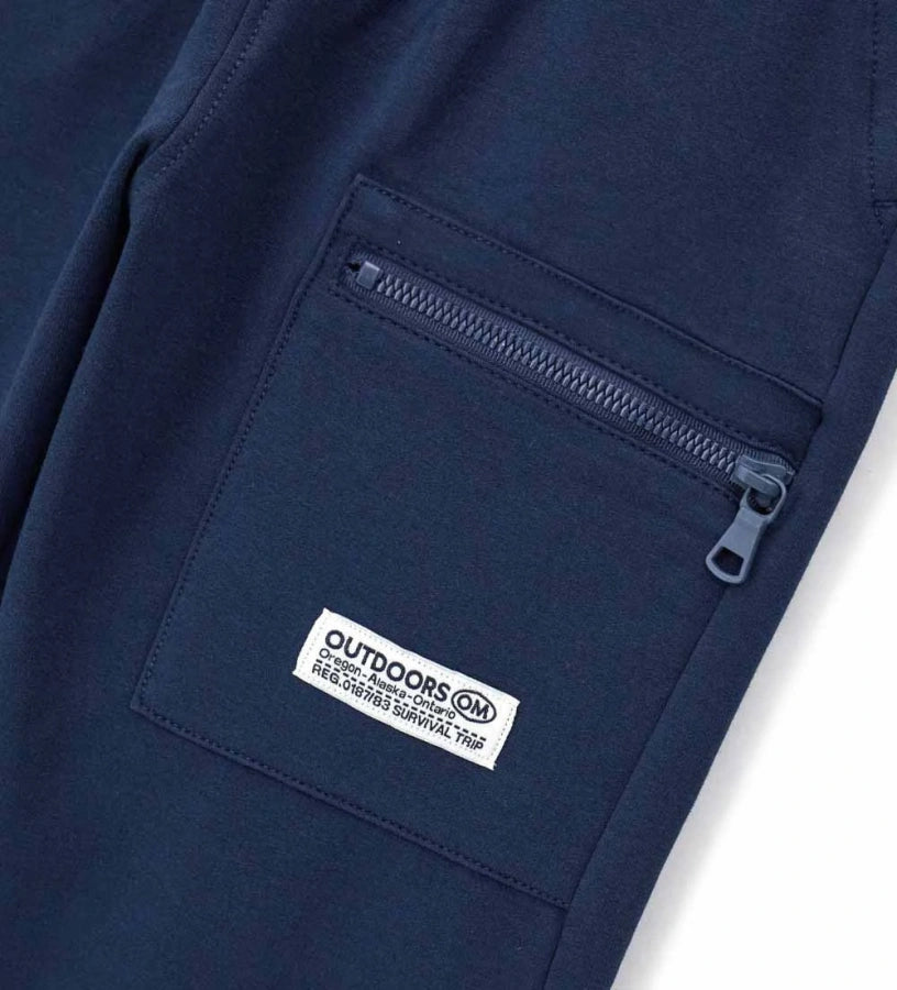 Παντελόνι από ζεστό βαμβακερό fleece, άνετο και μοντέρνο. Η ρυθμιζόμενη και ελαστική μέση προσφέρει εξαιρετική άνεση, ενώ η πρακτική μπροστινή τσέπη με φερμουάρ προσθέτει μια πινελιά στυλ. Ριμπ τελειώματα και ετικέτα στο μπροστινό μέρος ολοκληρώνουν την προσεγμένη εμφάνιση.