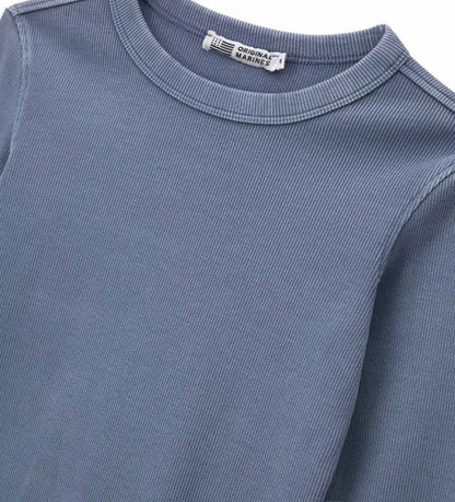 Μπλούζα από βαμβάκι σε ριπ ύφανση και βαφή ενδύματος, με απλό και μοντέρνο στιλ. Διαθέτει μακριά μανίκια και στρογγυλή λαιμόκοψη για άνεση και πρακτικότητα, καθώς και κεντημένη ετικέτα για κομψή και ξεχωριστή πινελιά.