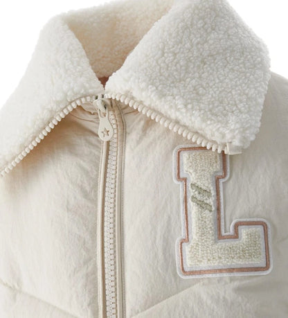 Μπουφάν από καπιτονέ και αφρώδες νάιλον με γιακά από οικολογική γούνα και μακριά μανίκια. Διαθέτει φόδρα από νάιλον, φερμουάρ σε μονόχρωμο τόνο, μπροστινές τσέπες και κεντημένο σήμα για ένα ζεστό, κομψό και μοντέρνο στυλ, ιδανικό για τις κρύες μέρες του χειμώνα.